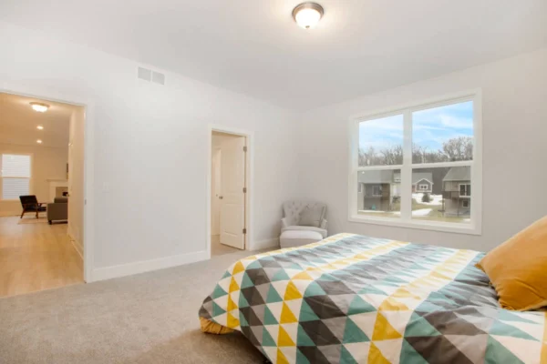 IMG_0302 Bedroom with geometric-patterned bedspread, window view, chair in corner, and door to adjoining rooms.