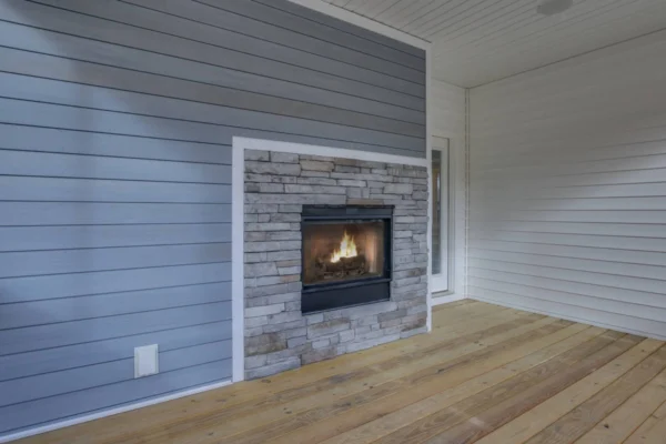 IMG_6438Blended Indoor fireplace on a wooden floor with stone and blue siding wall. White ceiling and walls surround the area.