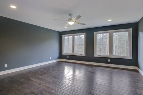 IMG_6444Blended Spacious room with wood flooring, gray walls, two large windows, ceiling fan, and recessed lighting.