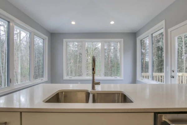 IMG_6546Blended Modern kitchen sink with a view of large windows showcasing a forest outside.