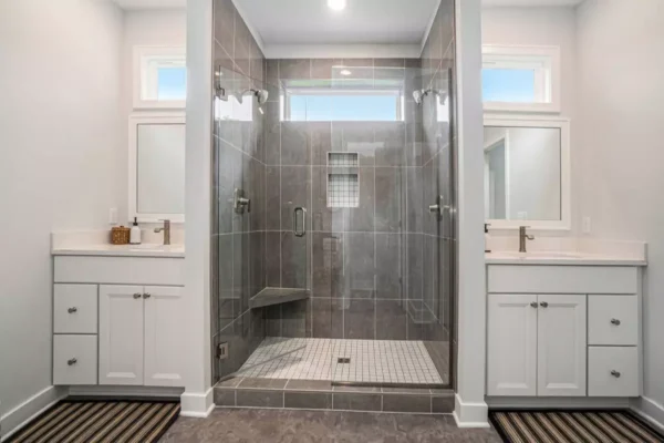 DSC00064 Modern bathroom with a large glass walk-in shower between two white vanities and windows above.